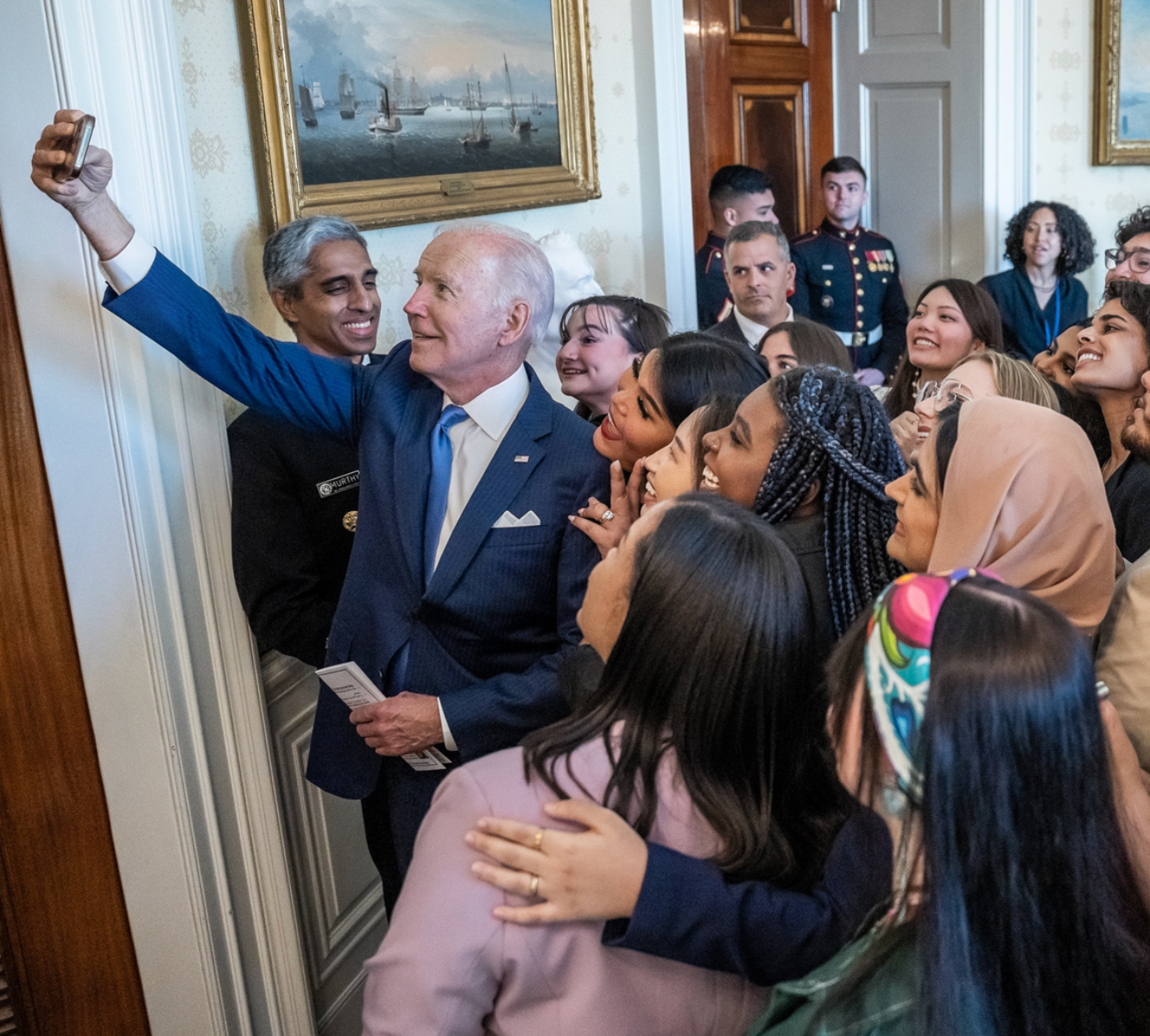 President Joe Biden takes a selfie with mental health youth action forum participants, Wednesday, May 18, 2022, in the Blue Room of the White House