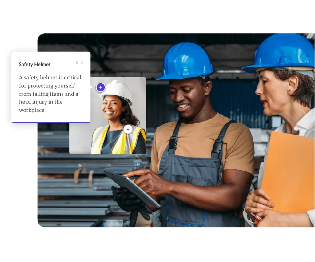 Two construction workers using a tablet for compliance training. The course features a label interaction with various markers over a person wearing safety gear. The “Safety Helmet” marker is selected, displaying the text: “A safety helmet is critical for protecting yourself from falling items and head injuries in the workplace.”